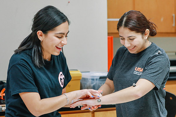 Kinesiology student placing motion capture devices on a student volunteer