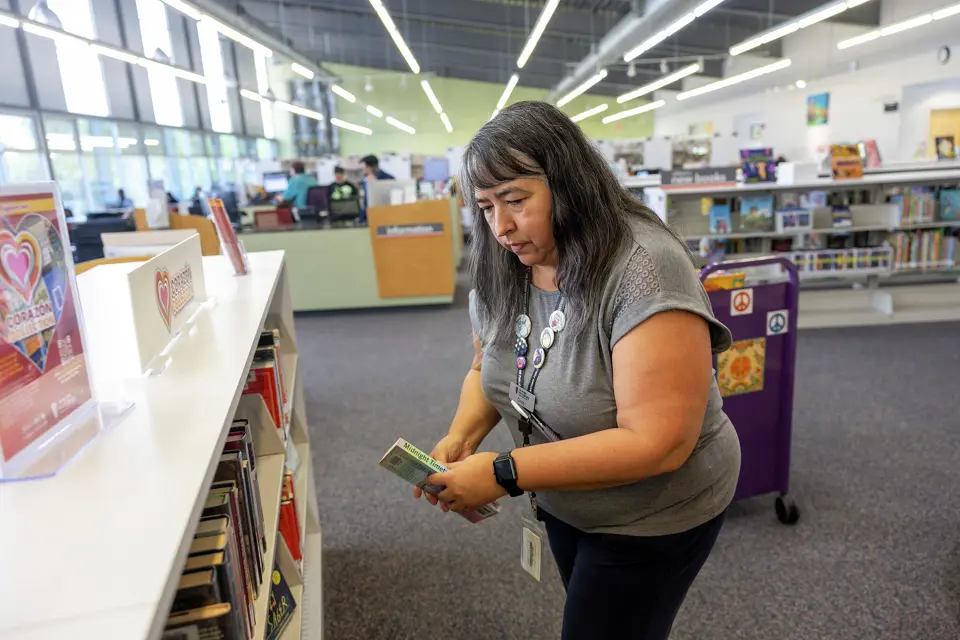 Cindy Garcia, library aide, returns books back to their shelves at the Guerra Branch Library earlier this month. Andrew J. Whitaker, San Antonio Express-News