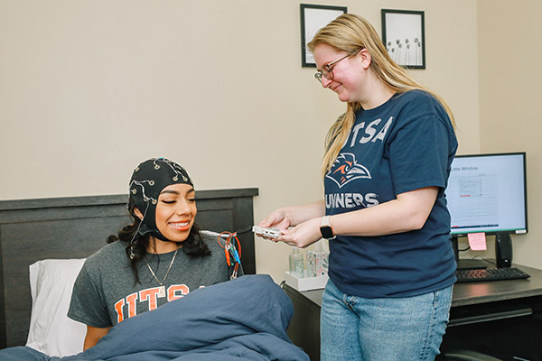 Student volunteer being connected to a sleep monitoring device for a session